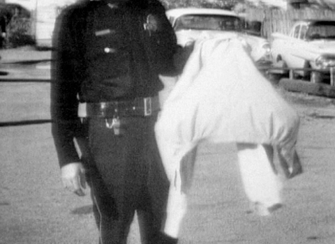 An Officer Holding the Light-Gray Jacket Found on the Killer’s Escape Route